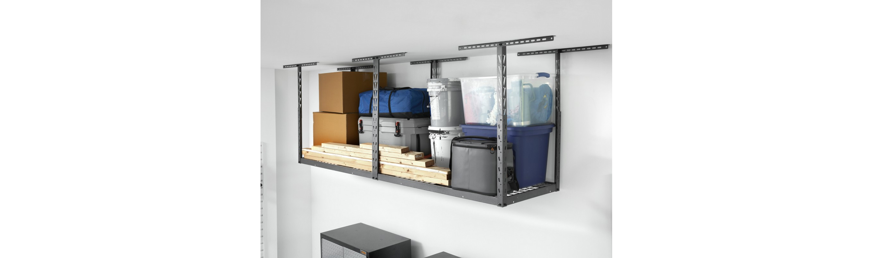 A Gladiator Overhead Storage with stacks of lumber next to a grey cooler and in front of bins, canisters and boxes