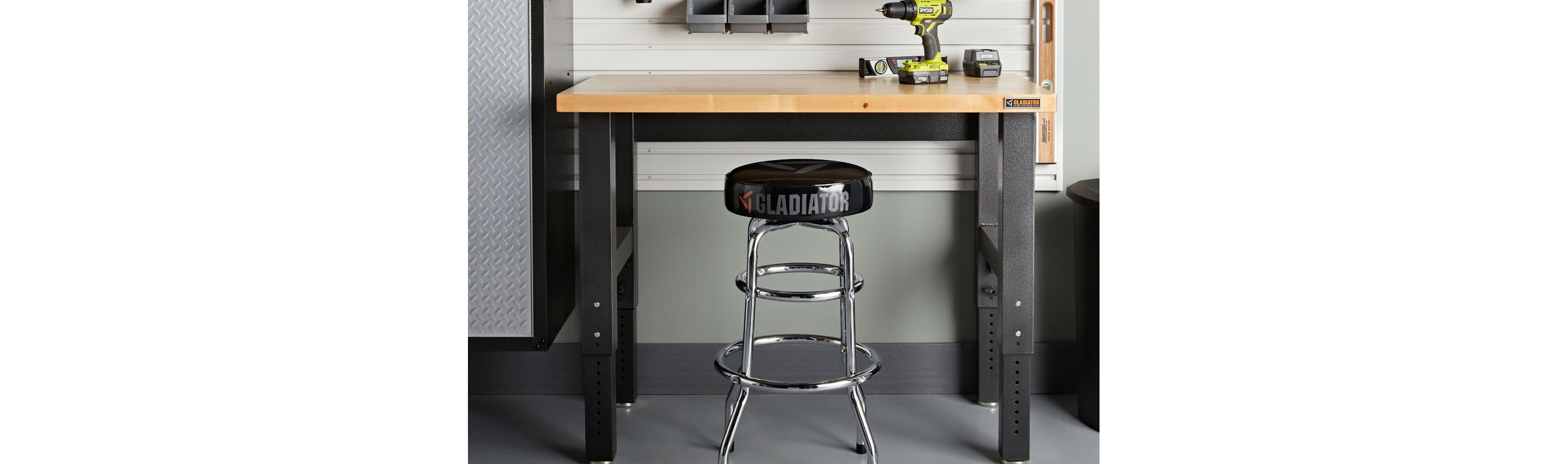 A Gladiator Workbench with a drill on top. There's a stool and Gladiator Bins on the wall